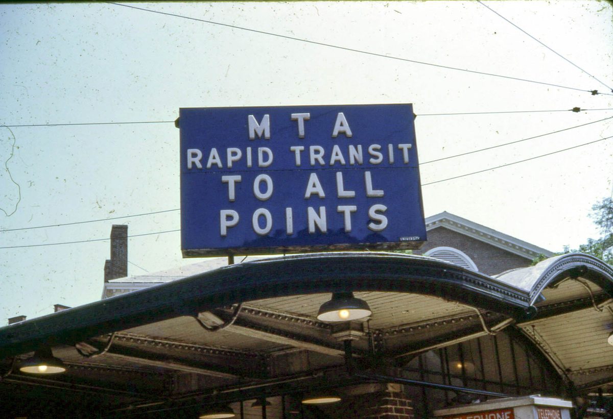 1967'de Harvard Square metro istasyonunun kemerli girişi ve üstünde MTA Rapid Transit to All Points yazan mavi tabela