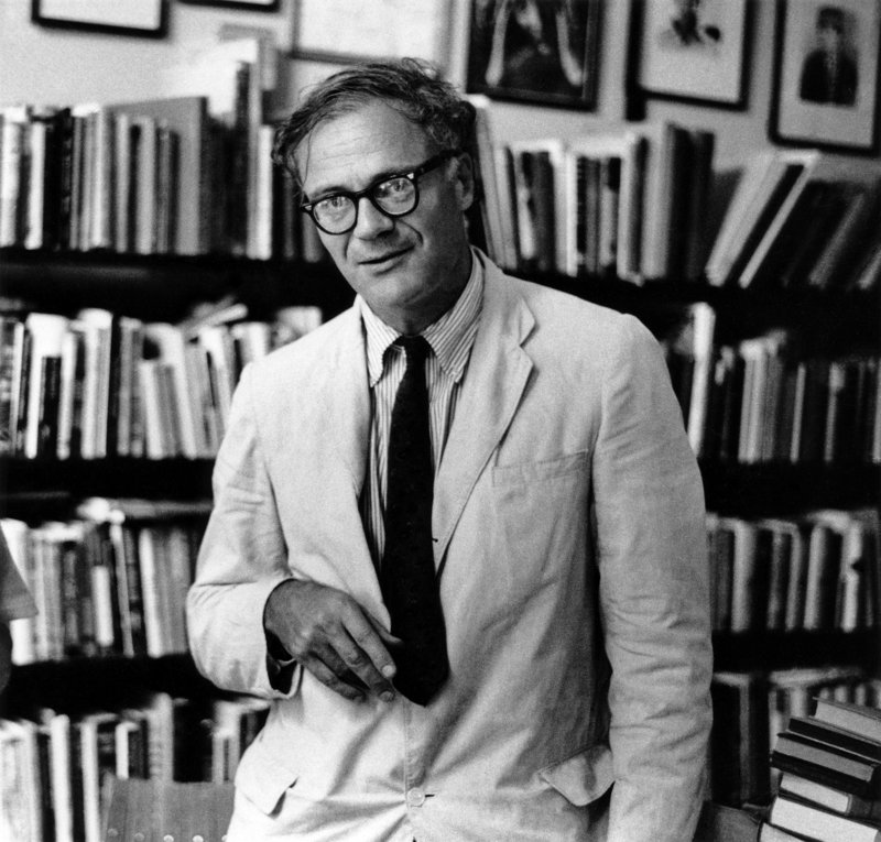 Robert Lowell, 1960'larda Harvard Meydanı'ndaki Grolier kitapçısında, kitap rafları önünde gözlüklü ve açık renk ceketli