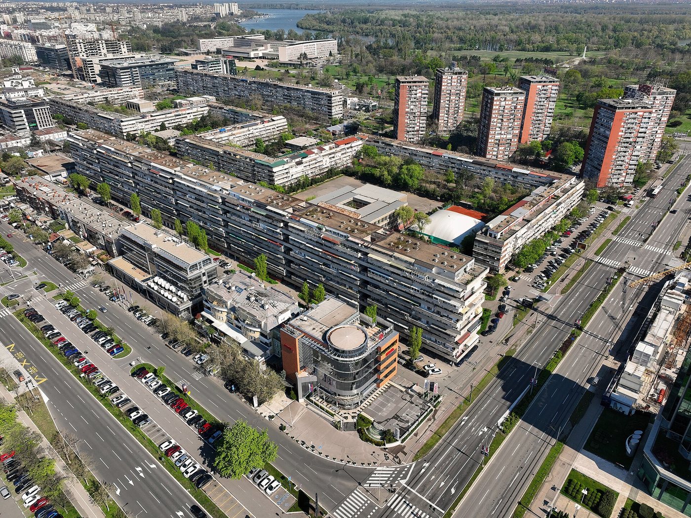 Yeni Belgrad'daki 21. Blok'un havadan görünümü: uzun, alçak apartman sıraları, arkada kırmızı cepheli dört kule ve Sava kıyısı