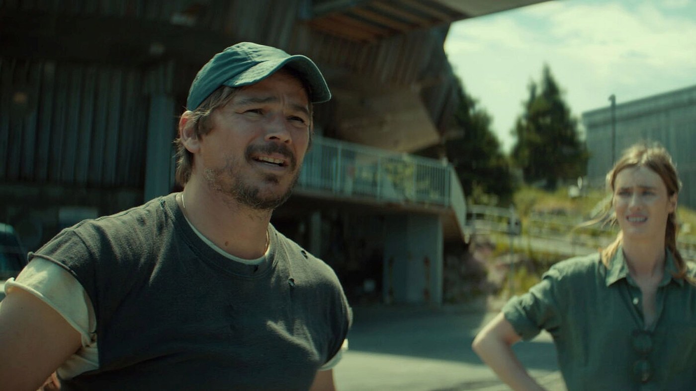 Below dizisinden bir kare: şapkalı Josh Hartnett ve Mackenzie Davis bir binanın önünde, Hartnett yukarı bakıyor