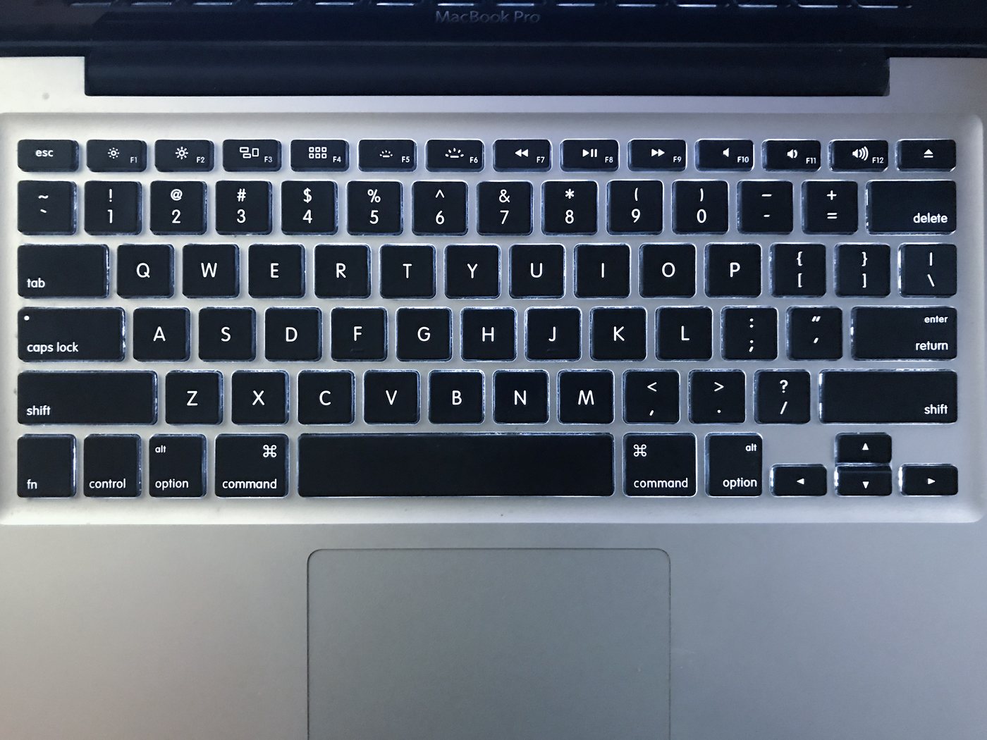 MacBook Pro klavyesinin yakından çekilmiş fotoğrafı, arka ışık yanık