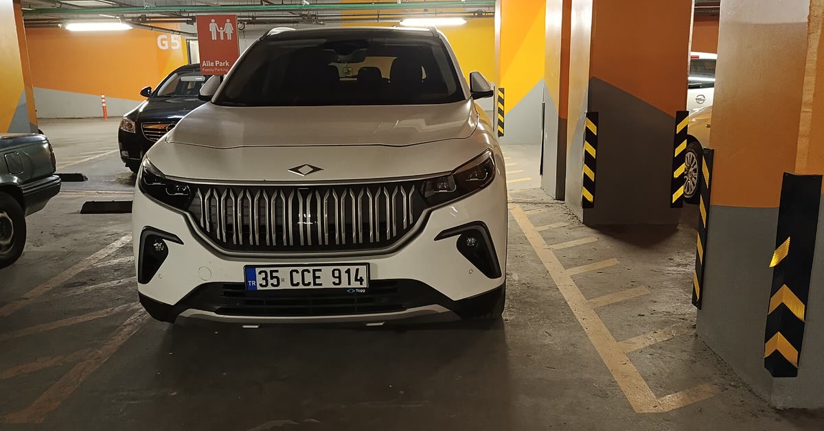 Bir alışveriş merkezi otoparkında İzmir plakalı beyaz Togg T10X