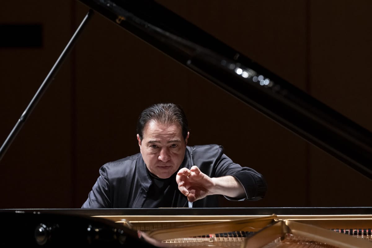 Fazıl Say Tokyo'daki konserde kuyruklu piyanonun başında, sağ eli havada