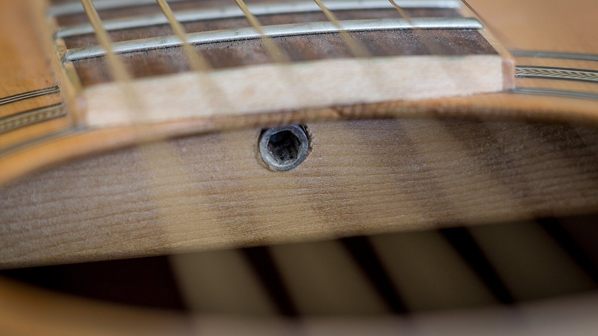 Akustik gitarın ses deliğinden görünen sap çubuğu ayar somunu