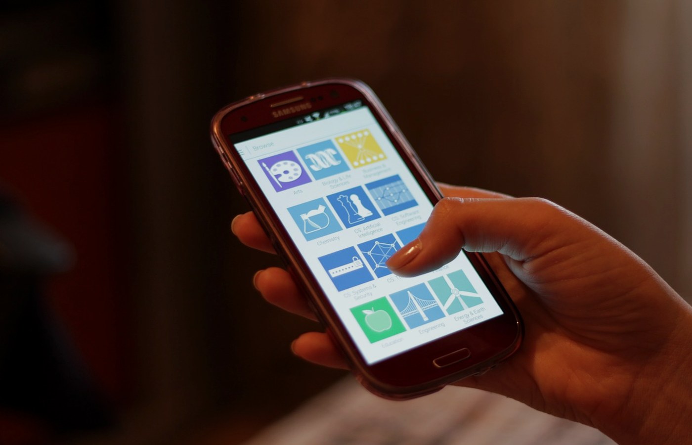 Elinde akıllı telefon tutan bir kişi, ekranı okuyor