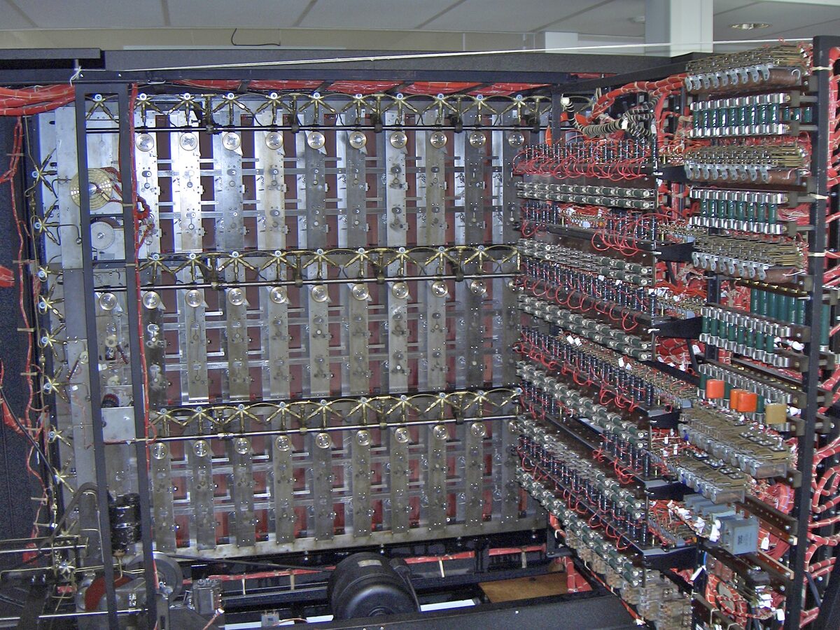 Bletchley Park'ta yeniden inşa edilen bombe makinesinin arka yüzü: metal raflarda sıra sıra röleler ve yüzlerce kırmızı kablo