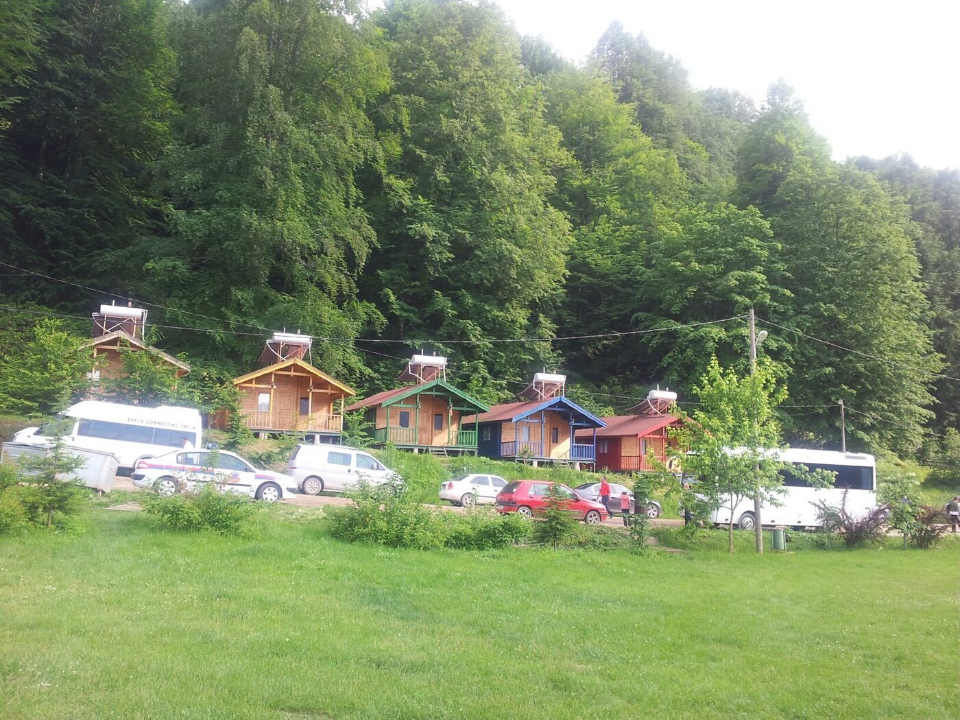 Güzeldere Şelalesi Tabiat Parkı'nda ahşap evler ve çayır