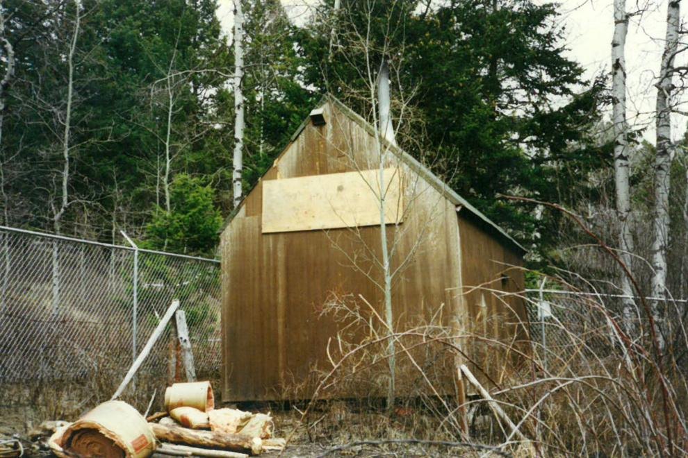 Montana'da ormanın içinde, etrafı tel örgüyle çevrilmiş küçük ahşap kulübe; FBI'ın Nisan 1996'da çektiği delil fotoğrafı
