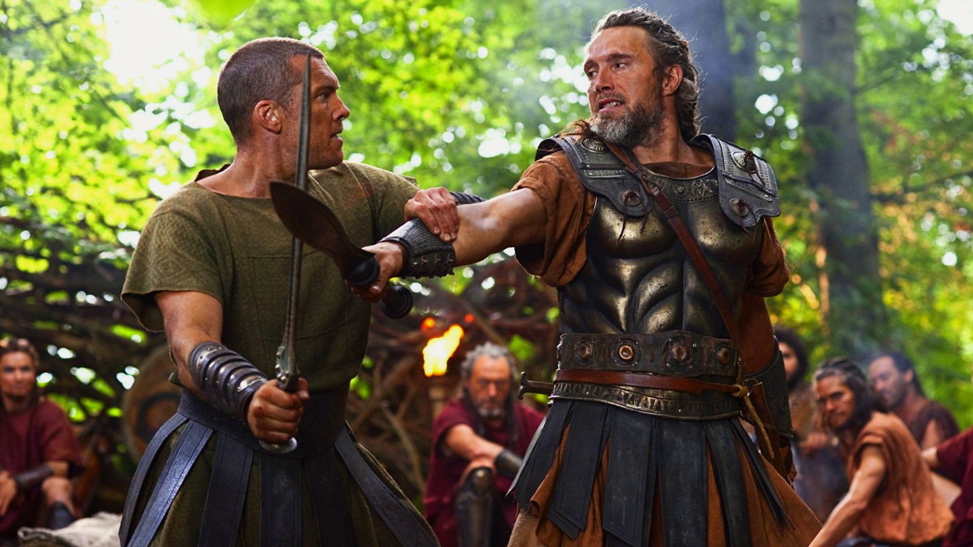 Titanların Savaşı filminde ormandaki bir kampta kılıç talimi yapan Sam Worthington ve Mads Mikkelsen