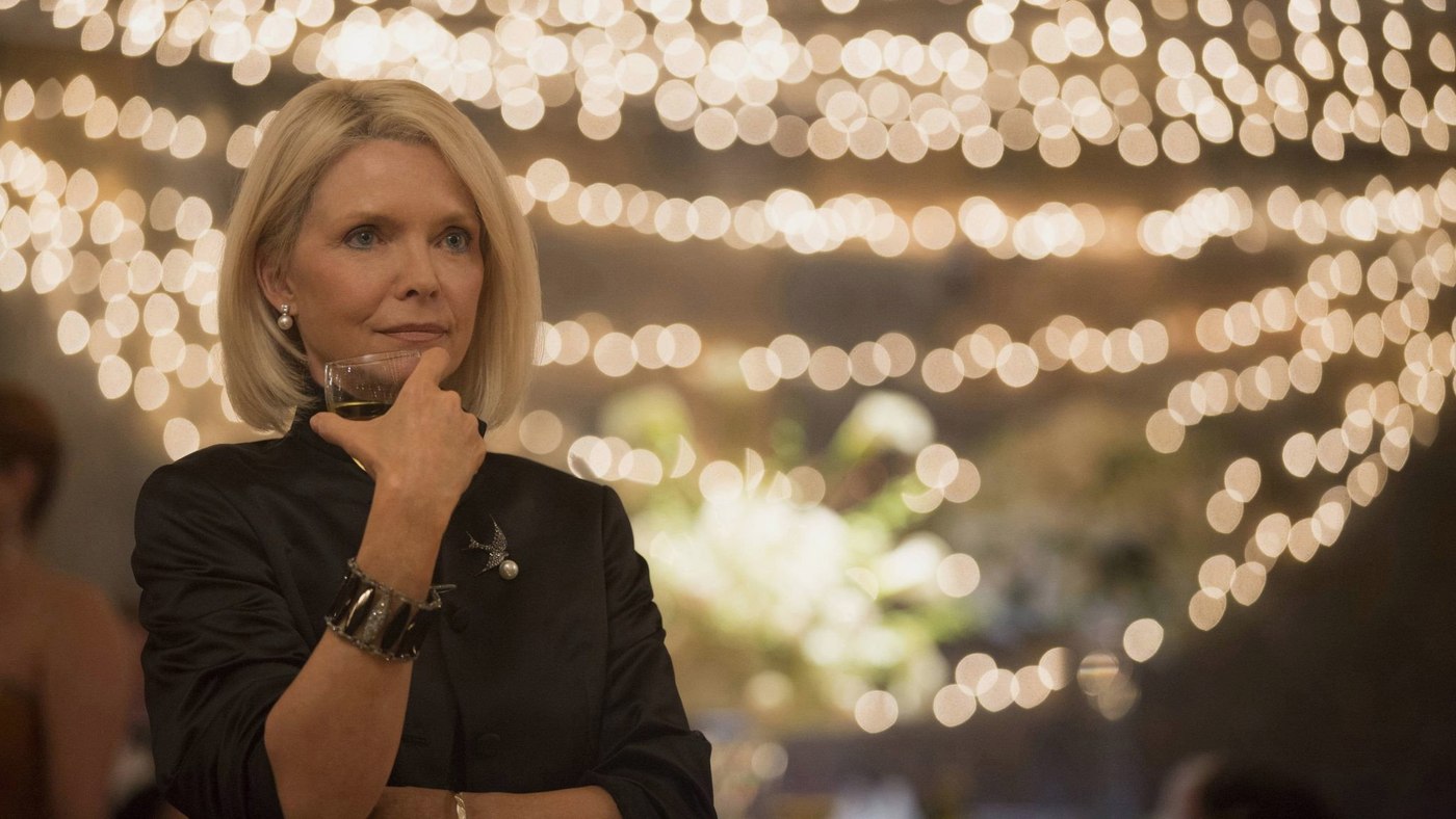 Yalanlar Büyücüsü filminde ışıklarla süslü bir davette elinde kadehle düşünceli duran Michelle Pfeiffer